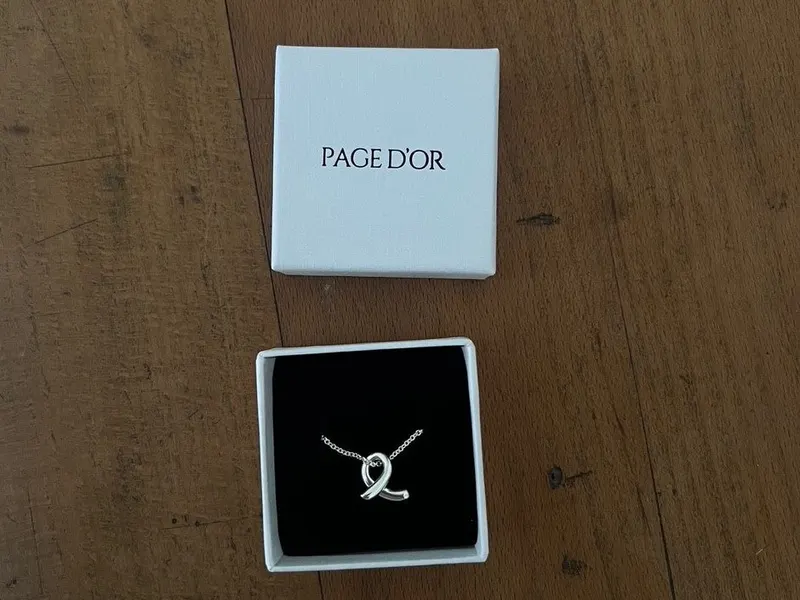 Le collier sur mesure de Hafsa présenté dans son écrin Page d'Or